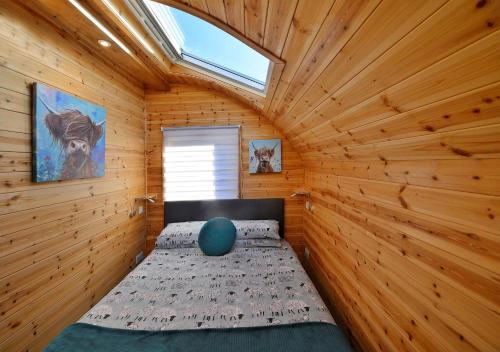 フォート・ウィリアムにあるFinest Retreats - Dalaraban Luxury Pods - Black Grouseの木製の部屋にベッド1台が備わるベッドルーム1室があります。