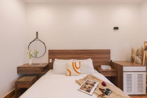 a bedroom with a bed with a mirror on it at The Morris Central Hotel - O'TEL in Da Lat