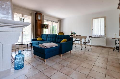 - un canapé bleu dans le salon avec cheminée dans l'établissement La Maryzalin - proche Montélimar, à Sauzet