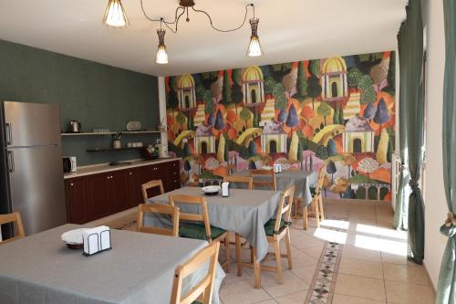 a kitchen with two tables and a painting on the wall at B&B Da Fifi in Castel San Giorgio