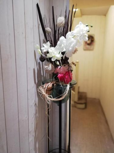 a vase filled with white flowers in a room at Parenthèse in Beuzeville