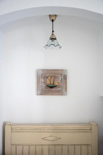 a painting of a boat on a wall with a lamp at La Goleta in Llança