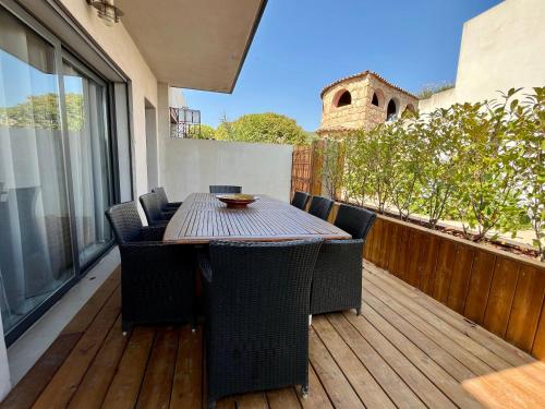 a wooden deck with a table and chairs on a balcony at Résidence Storia di Blue in Porto-Vecchio