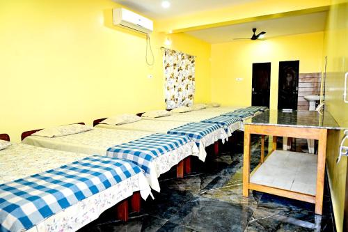 a row of beds in a room with yellow walls at Socials by bablos in Molem