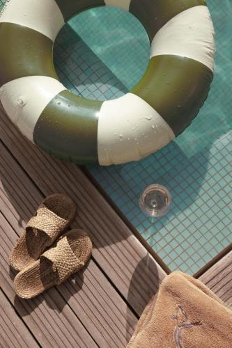 a pair of sandals sitting next to a swimming pool at Jnan Lotf Marrakech - Le Jardin de la Bienveillance in Marrakech