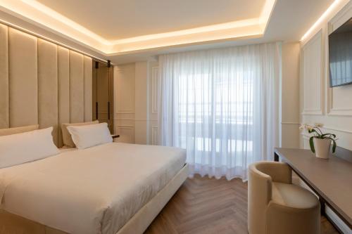 a bedroom with a bed and a desk and a window at Park Hotel Cattolica & Restaurant in Cattolica