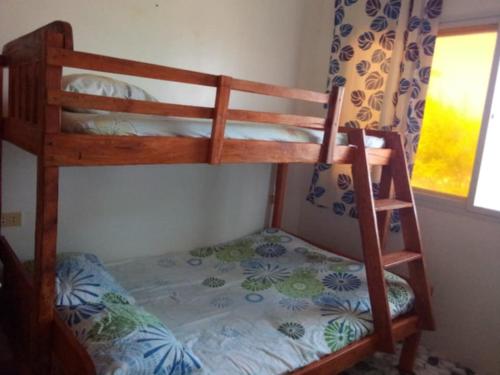two bunk beds in a room with a window at Uncle Bob&Tere Beachfront House in Luna