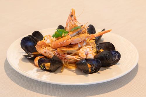 a plate of food with shrimp and mussels on a table at Park Hotel Cattolica & Restaurant in Cattolica