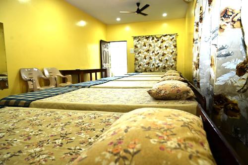 a row of beds in a room with yellow walls at Socials by bablos in Molem