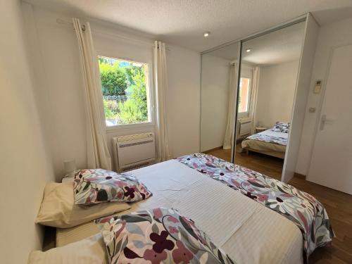 a bedroom with two beds and a large mirror at Jardin d azur Magnifique vue mer et piscine in Cavalaire-sur-Mer