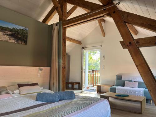 une chambre avec deux lits et une grande fenêtre dans l'établissement La Grange du Born, à Sainte-Eulalie-en-Born