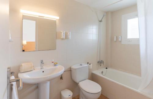 a bathroom with a sink and a toilet and a bath tub at Bay Hotel in Roses