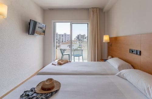a hotel room with two beds and a balcony at Bay Hotel in Roses