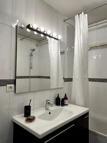une salle de bain blanche avec un lavabo et un miroir dans l'établissement F3 60 m2 - Paris Villejuif - Orly - Parking, à Villejuif