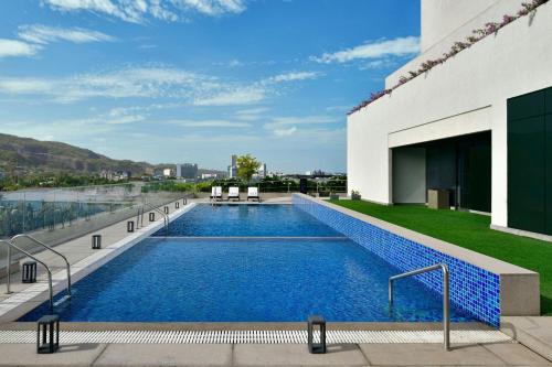 a swimming pool on the roof of a building at Marriott Executive Apartments Navi Mumbai in Navi Mumbai