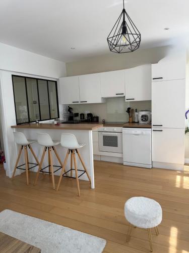 une cuisine avec des armoires blanches et une table et des chaises dans l'établissement Espace détente ou de travail à 1h de Paris, à Mantes-la-Jolie