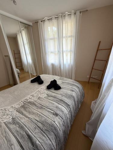 - une chambre dotée d'un lit avec deux chaussures noires dans l'établissement Espace détente ou de travail à 1h de Paris, à Mantes-la-Jolie