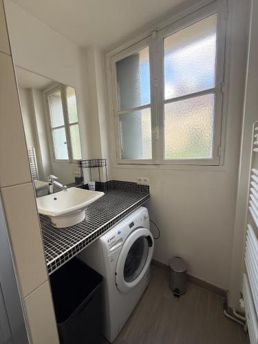une salle de bain avec une machine à laver et un lavabo dans l'établissement Espace détente ou de travail à 1h de Paris, à Mantes-la-Jolie