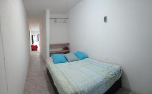 ハラパにあるDepto Zona UV Lagos Isleta 102の白い部屋のベッド1台(青い枕付)