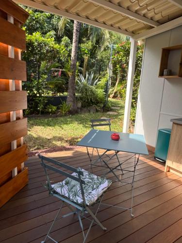 a table and a chair on a deck at La Kaz Iléou in Saint-Joseph