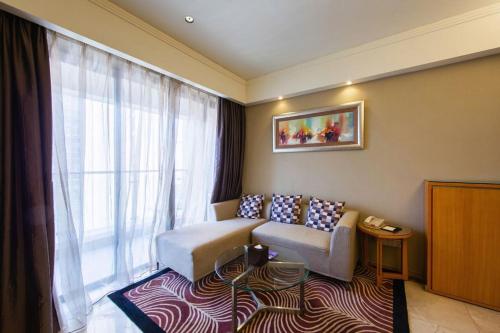 a living room with a couch and a large window at 广州丹顿行政公寓珠江新城店-广交会期间免费穿梭巴士 in Guangzhou