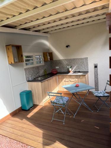 a kitchen with a table and chairs in a room at La Kaz Iléou in Saint-Joseph