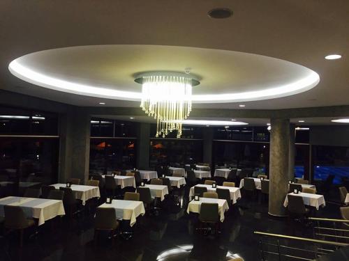 a dining room with white tables and a chandelier at Pasa Garden Beach in Marmaris