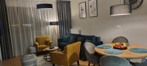 un salon avec une table et des chaises dans l'établissement Słoneczne Sarbinowo - Apartament Marynarska 10, à Sarbinowo