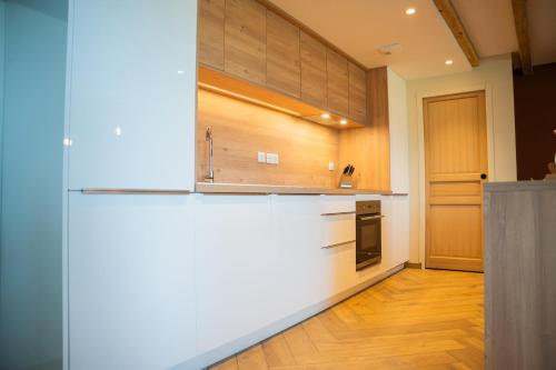 a kitchen with a white counter top and wooden cabinets at Les Granges du Hautacam in Artalens-Souin