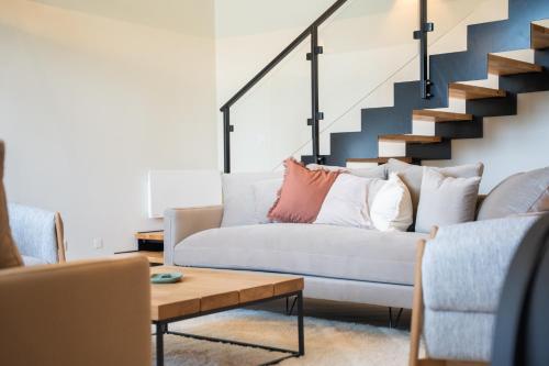 a living room with a couch and stairs at Les Granges du Hautacam in Artalens-Souin