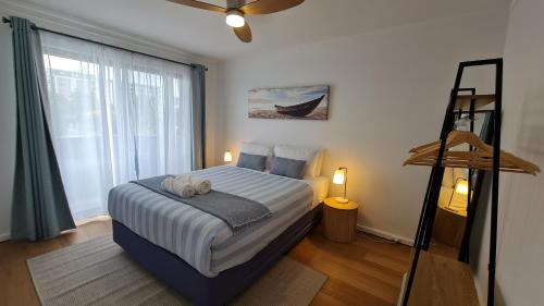 une chambre avec un lit et une grande fenêtre dans l'établissement NEW Coastal Salty Life - 2 bed 1st Floor, à Perth