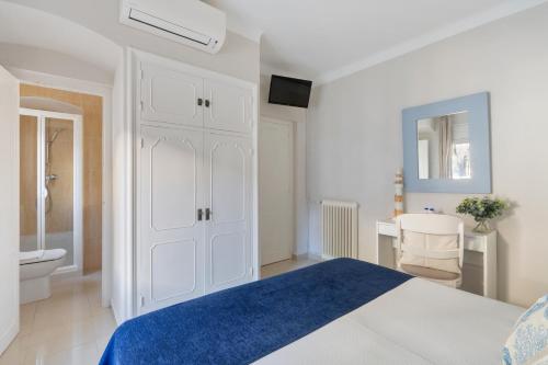 a white bedroom with a bed and a toilet at La Goleta in Llança