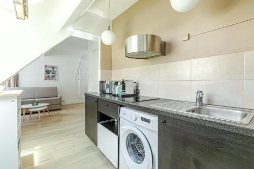 une cuisine avec une machine à laver et un évier dans l'établissement Appartement Gare de Lyon - Bastille lumineux, à Paris