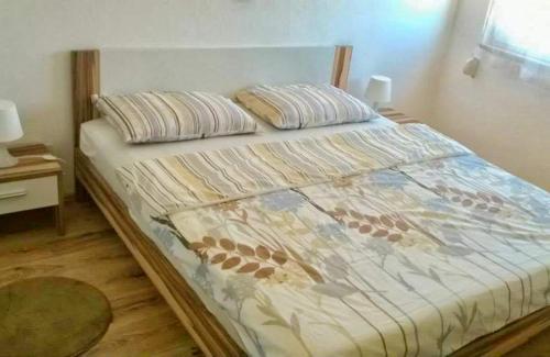 a bed with a comforter on it in a bedroom at Apartment Leni 2 in Banjole