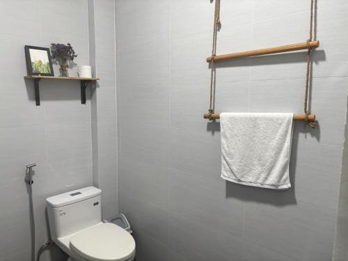 une salle de bain avec toilettes et une serviette blanche dans l'établissement Nhà mình Homestay, à Ấp Thanh Sơn (1)