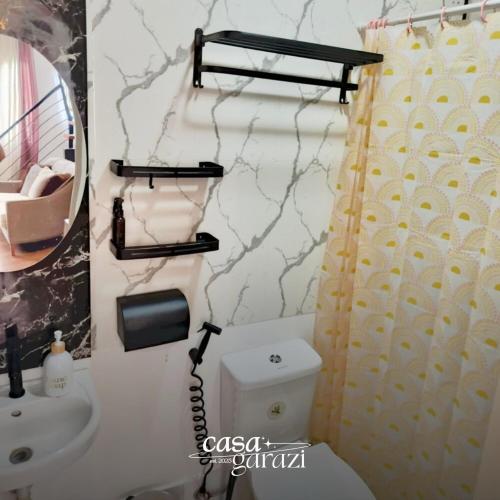 a bathroom with a toilet and a sink and a mirror at Casa Garazi in Calo