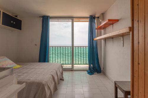 une chambre avec un lit et une grande fenêtre dans l'établissement Porte Rouge 2, au Pradet