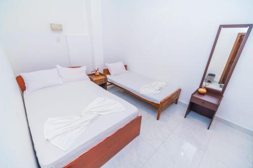 a bedroom with a bed and a mirror and a mirror at Cinnamon Airport Residencies in Katunayaka