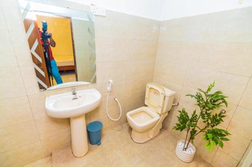 a bathroom with a sink and a toilet and a mirror at Cinnamon Airport Residencies in Katunayaka