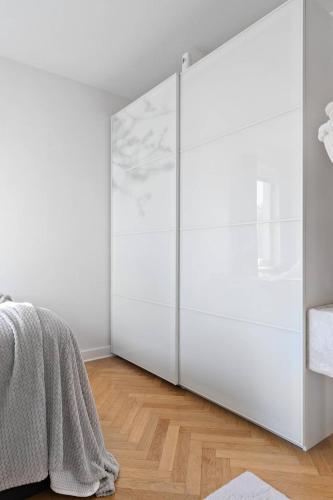 a bedroom with white walls and a large white closet at Apartament u Ann in Grzędzice