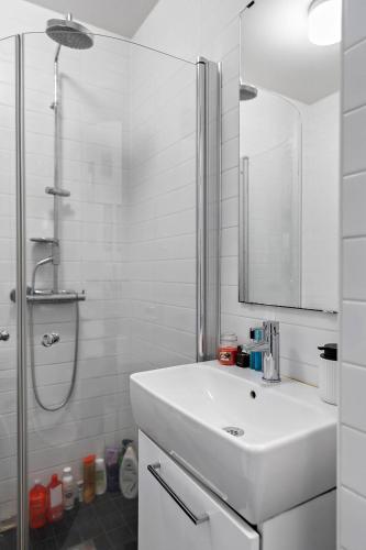 a white bathroom with a sink and a shower at Apartament u Ann in Grzędzice