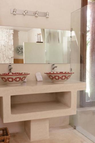 a bathroom with two sinks and a mirror at Jnan Lotf Marrakech - Le Jardin de la Bienveillance in Marrakech