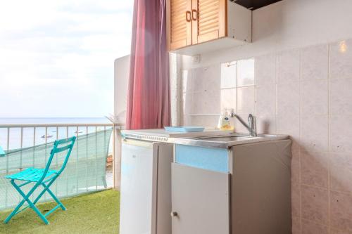 d'une cuisine avec un évier et une chaise sur un balcon. dans l'établissement Jeux de boules 5, au Pradet
