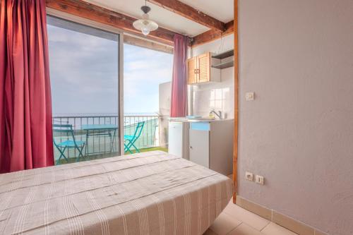 een slaapkamer met een bed en een groot raam bij Jeux de boules 5 in Le Pradet