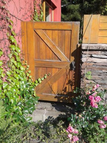 a wooden door in a garden with pink flowers at Chalupa u Žalských in Benecko