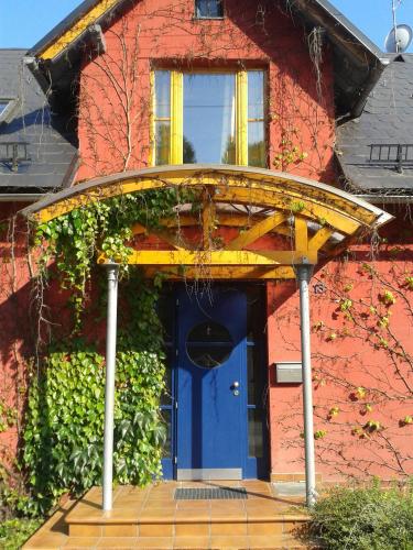 a blue front door of a red house with a yellow roof at Chalupa u Žalských in Benecko
