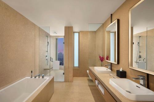 a bathroom with two sinks and a tub and a shower at Marriott Executive Apartments Navi Mumbai in Navi Mumbai