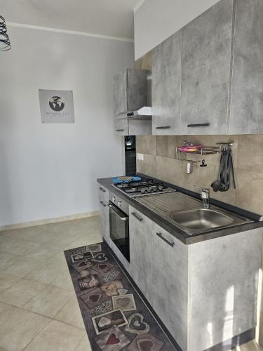 a kitchen with a sink and a stove at 40 Parallelo in Castel Volturno