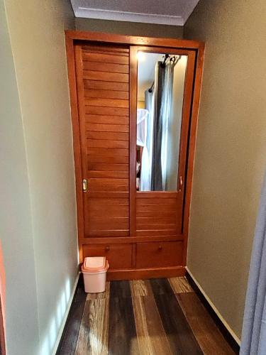 a bathroom with a toilet and a wooden door at Sarnah Apartments in Arusha