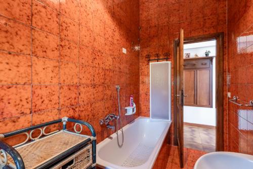 a bathroom with an orange tiled walls and a bath tub at Villino Ruben in Fucecchio
